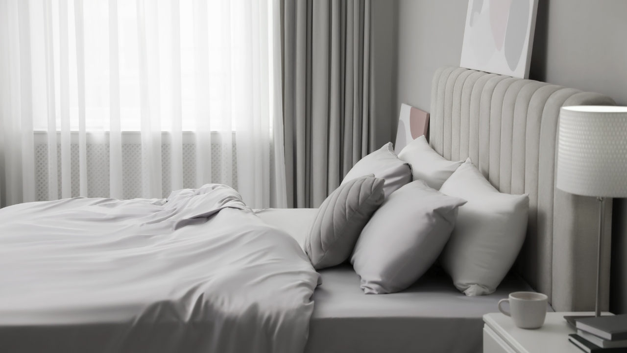 Uređen bračni krevet sa jastucima i stabilnim ivicama u spavaćoj sobi